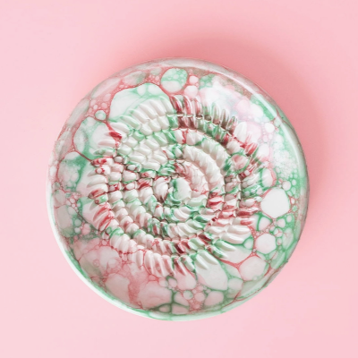 Prato cerâmico colorido com padrão de bolhas e relevo ao centro