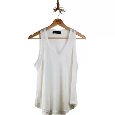 Camisola branca de alças pendurada num cabide de madeira