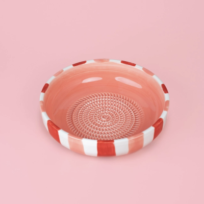 Tigela cerâmica redonda com padrão espiral no fundo e borda às riscas rosa, branco e vermelho
