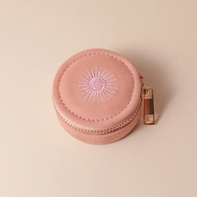 Estojo pequeno redondo cor de rosa com bordado branco e fecho dourado