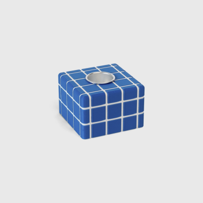 Vela decorativa quadrada azul com padrão de grelha branca e suporte metálico redondo