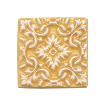 Azulejo decorativo amarelo com padrão floral branco em relevo
