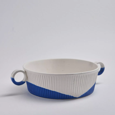 taça de cerâmica branca e azul com duas pegas redondas