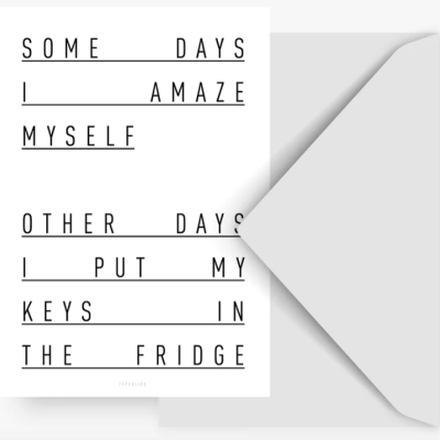 Cartão branco com texto em letras maiúsculas preto dentro de envelope cinzento aberto