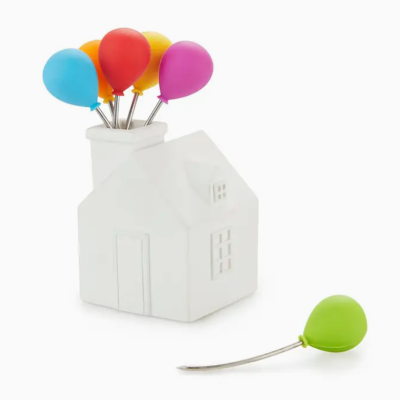 Alfinetes coloridos em suporte branco em forma de casa