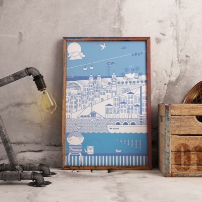 Pôster ilustrativo em moldura de madeira com cena costeira em azul e branco, lâmpada industrial e caixa de madeira ao lado.