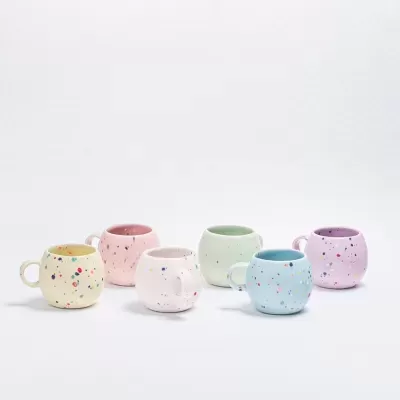 Seis canecas de cerâmica coloridas com manchas multicoloridas sobre fundo branco