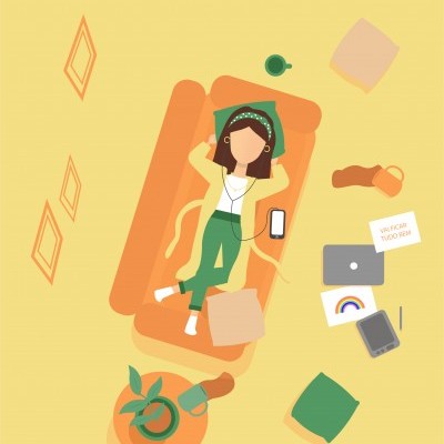 Jovem deitada num sofá com auscultadores e objetos em redor