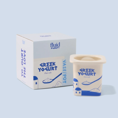 Vaso cerâmico branco e azul e embalagem com texto sobre iogurte grego.