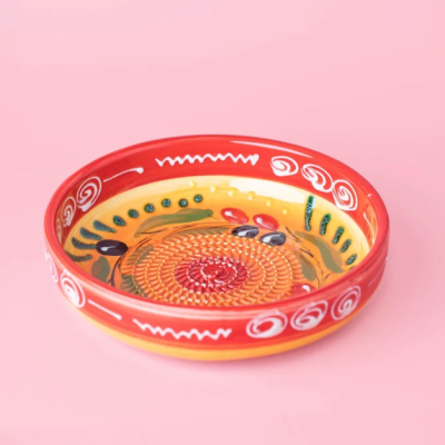 Prato de cerâmica colorido com borda vermelha e decoração de frutas