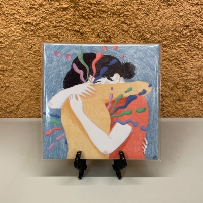 Ilustração de duas pessoas a abraçar com cores vibrantes, em moldura sobre suporte negro