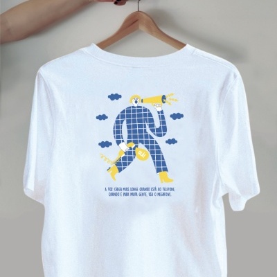 T-shirt branca com estampa colorida de figura humana segurando megafone e microfone e texto em português