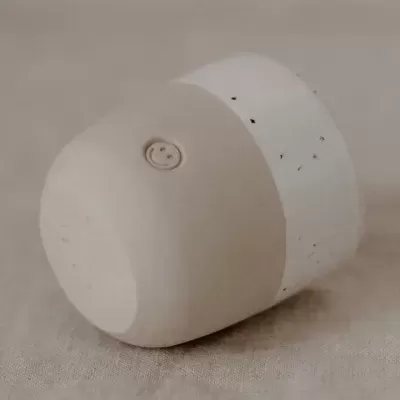 Vaso cerâmico bege claro com símbolo gravado e detalhes escuros