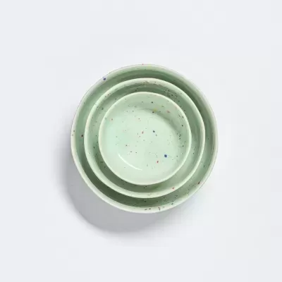 Conjunto de três taças verdes claro com pintilhas coloridas aninhadas.