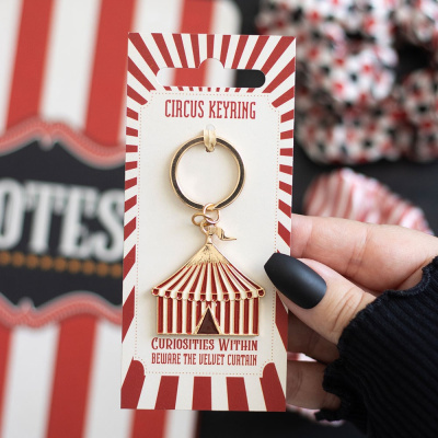 Chaveiro de tenda de circo vermelho e branco com embalagem correspondente.