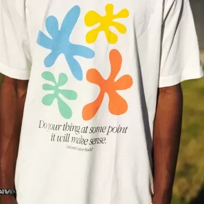 T-shirt branca com estampado colorido e texto preto