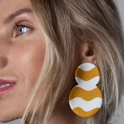 Brincos grandes redondos com padrão ondulado branco e amarelo mostarda