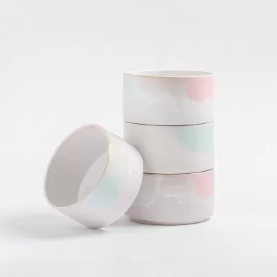 Quatro tigelas de cerâmica com padrão pastel e bordas douradas.