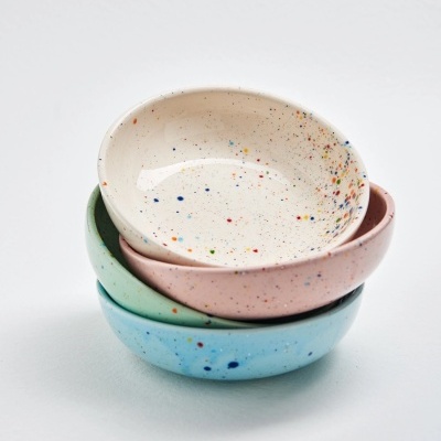 Três taças cerâmicas coloridas com salpicos empilhadas