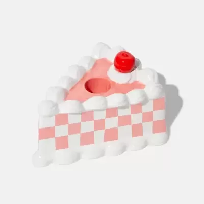 Figura em forma de fatia de bolo cor-de-rosa e branco com cereja de plástico