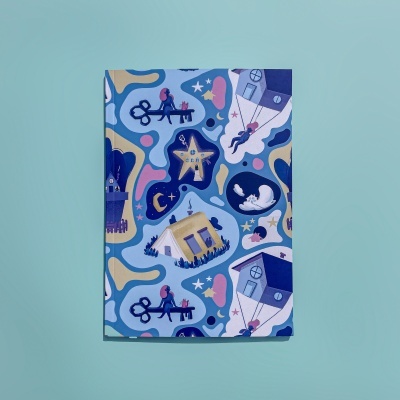 Caderno com capa decorada em tons de azul e bege com casas e personagens