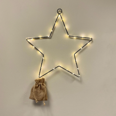 Estrela luminosa de metal preto com saco de juta pendurado
