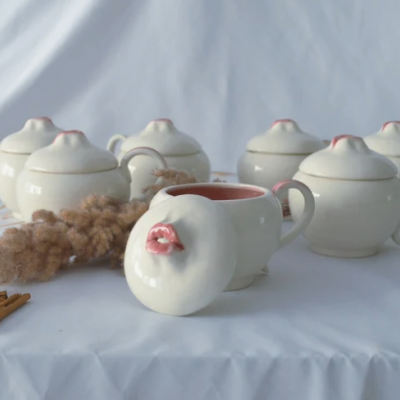 Conjunto de potes de porcelana brancos com tampas e detalhes rosa.
