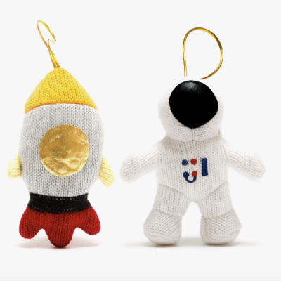 Brinquedos pendurados em crochê em forma de foguete e astronauta.