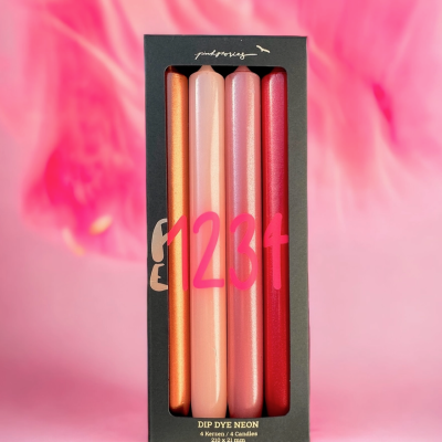 Conjunto de quatro velas neon em caixa preta sobre fundo rosa