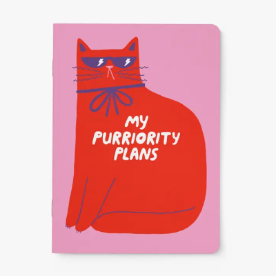 Caderno rosa com desenho de gato vermelho e texto em inglês.