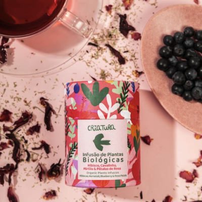 Embalagem floral de infusão biológica com chá e mirtilos ao redor