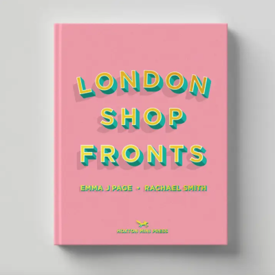 Livro rosa com título 'LONDON SHOP FRONTS' em amarelo e turquesa