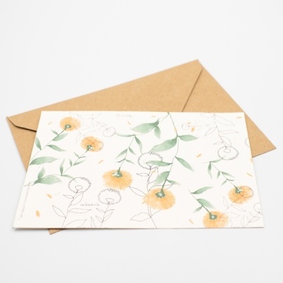 Cartão floral amarelo e verde sobre envelope castanho