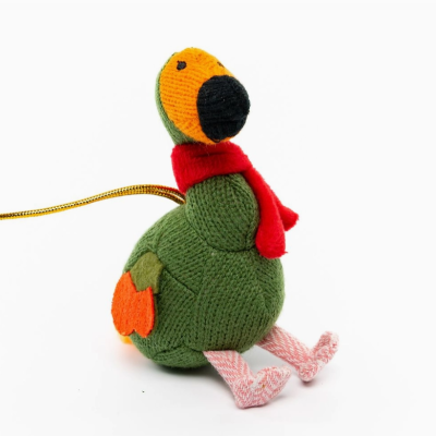 Boneco tricotado verde com cachecol vermelho e detalhes laranja sentado