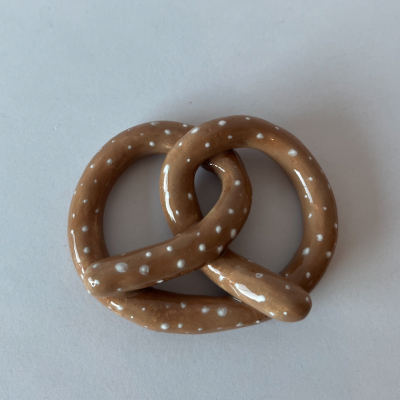 Pretzel castanho claro com pontos brancos sobre superfície branca