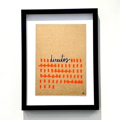 Quadro preto com papel castanho e traços laranja com palavra direitos