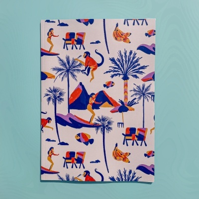 Caderno com capa ilustrada colorida de figuras tropicais e pessoas a surfar.