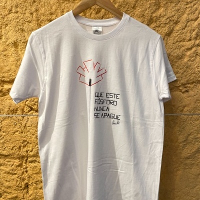 T-shirt branca com desenho e texto em preto e vermelho pendurada numa parede amarela