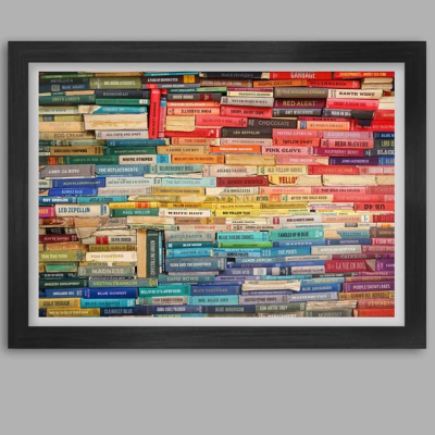 Quadro com moldura preta exibindo fotografia de livros organizados por cores