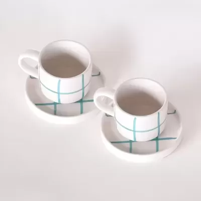 Duas chávenas e dois pires brancos com padrão azul