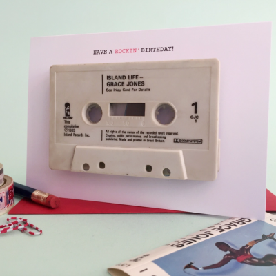 Cartão de aniversário com cassete colada e texto 'HAVE A ROCKIN' BIRTHDAY!' em fundo branco