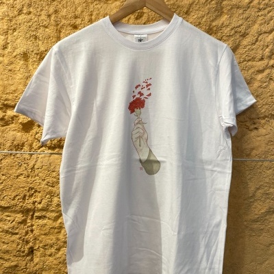 T-shirt branca com ilustração de mão segurando flor vermelha e corações saindo dela