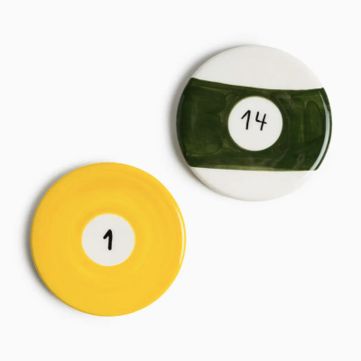 Dois pratos cerâmicos redondos, um amarelo com número 1 e outro branco com faixa verde e número 14