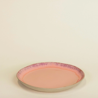 Prato de cerâmica rosa com borda lilás num fundo claro