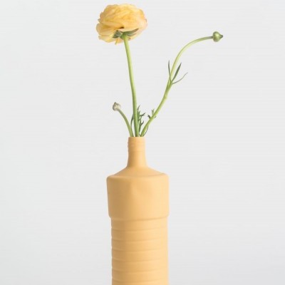 Vaso amarelo cerâmico em forma de garrafa com flor amarela