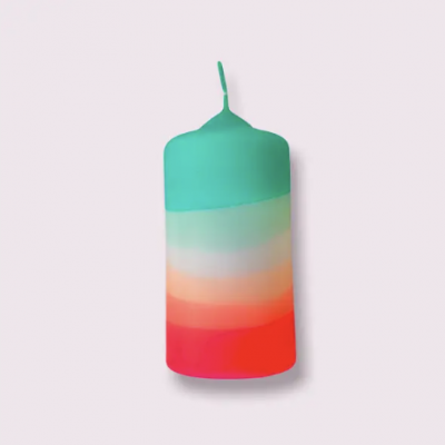 Vela cilíndrica colorida com listras horizontais em verde, branco, laranja e vermelho.
