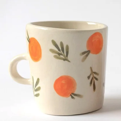 Caneca de cerâmica branca com padrão de laranjas pintadas