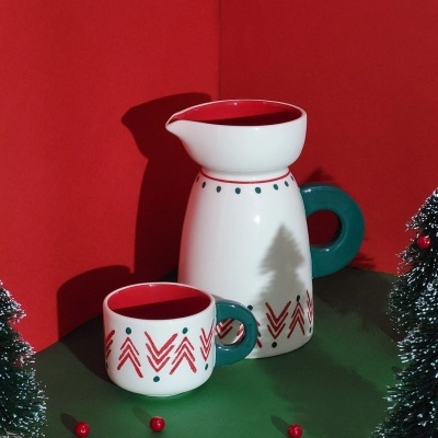 Conjunto de jarra e caneca decorados com tema natalício em fundo festivo