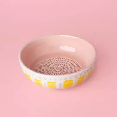 Taça em cerâmica rosa com padrão espiral e quadrados amarelos