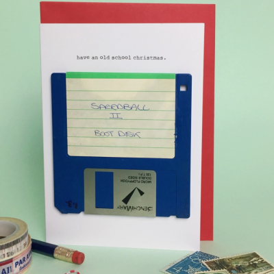 Cartão de Natal com disquete azul e texto 'have an old school christmas.'
